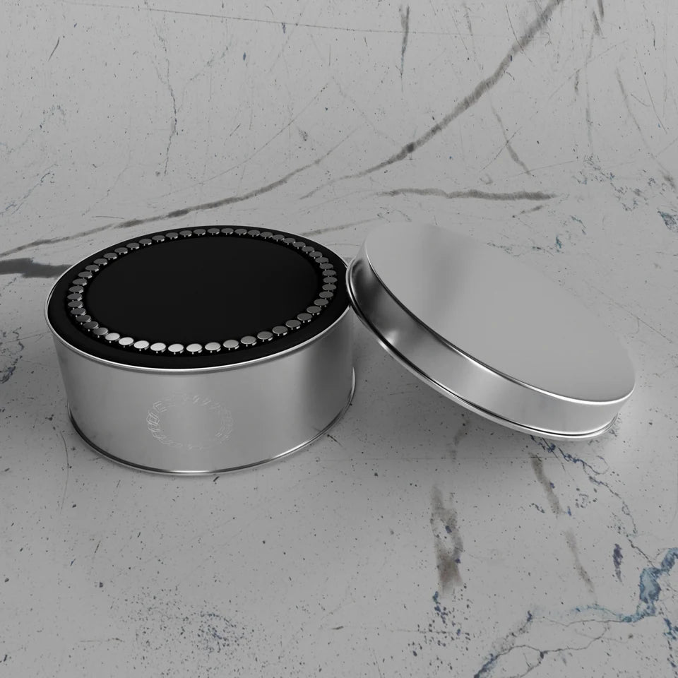 Magnetic bracelet presented in its round metal case on marble