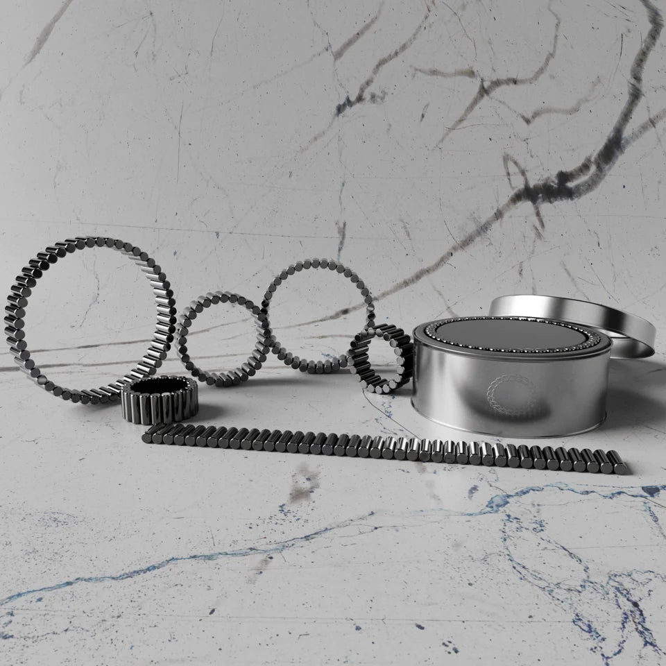 Magnetic cylinders arranged into rings, a chain and bracelets beside their presentation case